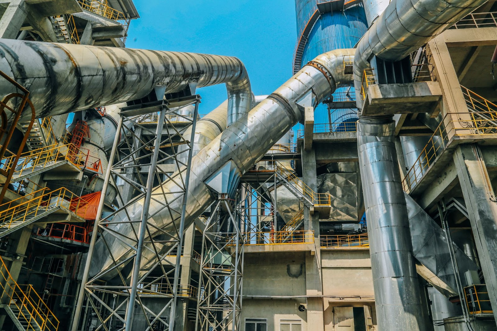 A complex network of industrial pipes and machinery at a chemical processing plant, representing advanced emission control technology.